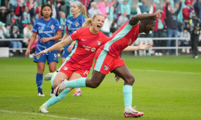 Kansas City forward Temwa Chawinga celebrates her first-half goal with her arms outstretched. Teammate Claire Hutton runs alongside her.