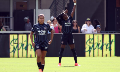 Gift Monday makes a shooting arrow motion in the background, celebrating a goal.